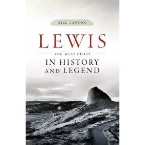 The cover of *Lewis: The West Coast in History and Legend* by Bill Lawson features a black-and-white photograph. In the image, a winding road travels through a landscape toward a rocky hill or outcrop. Above, the sky is filled with clouds. The composition includes contrasts between the lighter tones of the road and sky and the darker shades of surrounding terrain and rocks. No people or animals are visible in this landscape scene.