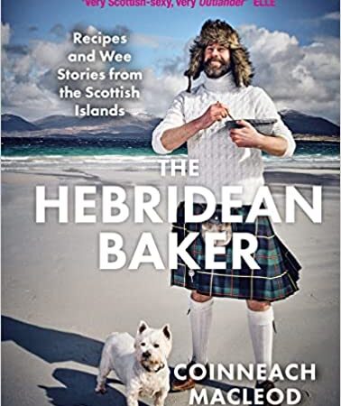 A man in a kilt and fur hat stands on a beach with mountains in the background. He is smiling and pointing. A small white dog is at his feet. The book title reads The Hebridean Baker by Coinneach Macleod.