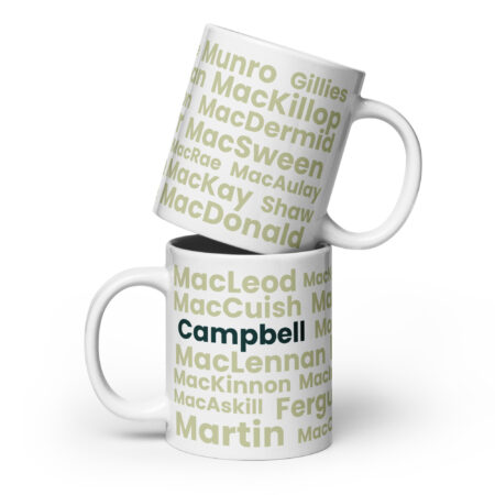 Two white mugs feature Scottish surnames in green and beige text. The bottom mug displays a bold Campbell design. One mug is stacked on top of the other.