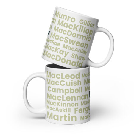 Two white mugs, each featuring green Kerr text associated with the Scottish surname, are shown. The mugs are stacked at an angle, with one positioned on top of the other.