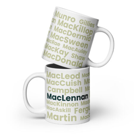 Two white mugs are stacked, each featuring Scottish surnames in green. The lower mug has MacLennan printed boldly in black, creating a personalized touch to this Mug - MacLennan set.