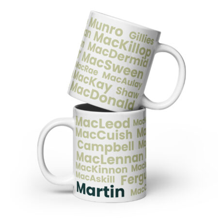 Two white mugs, each with a handle on the right side, are printed with pale green Scottish surnames. The bottom mug features the surname Martin in bold dark green type. These mugs can be used to recognize or highlight Scottish heritage, specifically relating to the surname Martin.