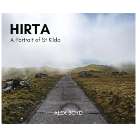 A gravel path winds through a misty, grassy landscape with rocky outcrops. Text: Hirta: A Portrait of St Kilda by Alex Boyd.