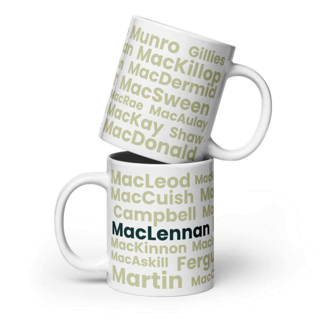 Two white mugs are stacked, each featuring Scottish surnames in green. The lower mug has MacLennan printed boldly in black, creating a personalized touch to this Mug - MacLennan set.
