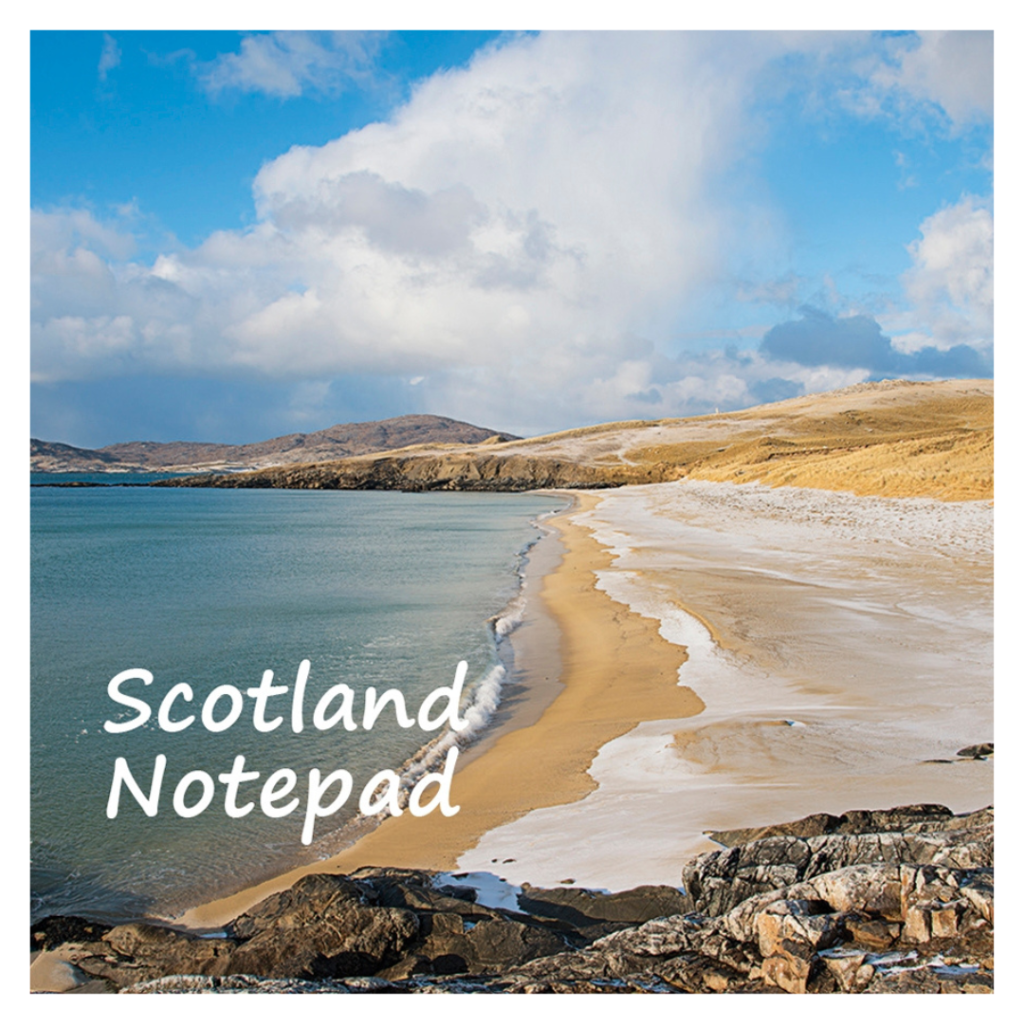 Sandy beach with gentle waves, rocky shores, partly cloudy sky, "Scotland Notepad" in white text; hills and grassy dunes behind.