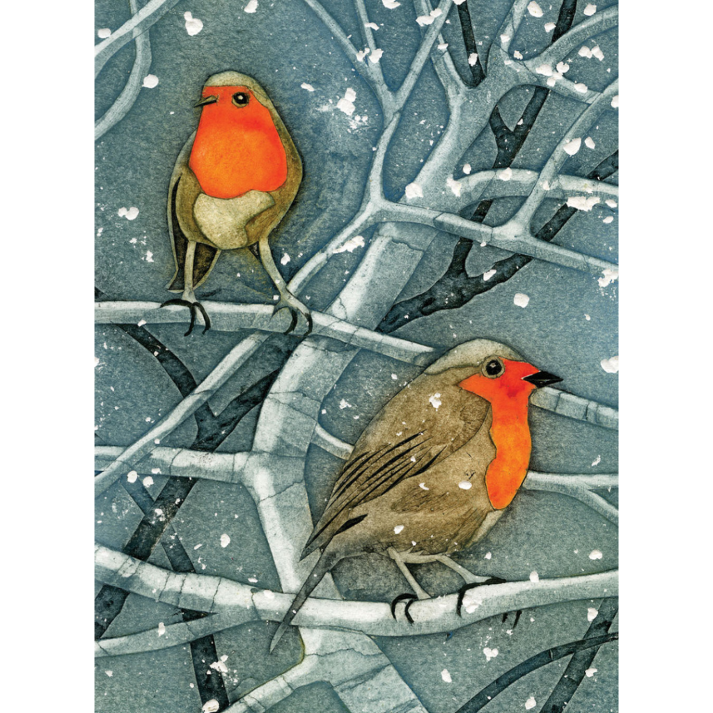 Two robins with red breasts perch on snow-dusted branches against a blue wintery background as snowflakes fall gently around them.